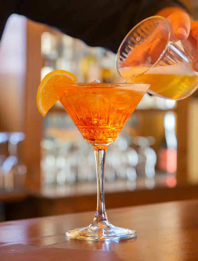 Il barman versa il cocktail nella coppa