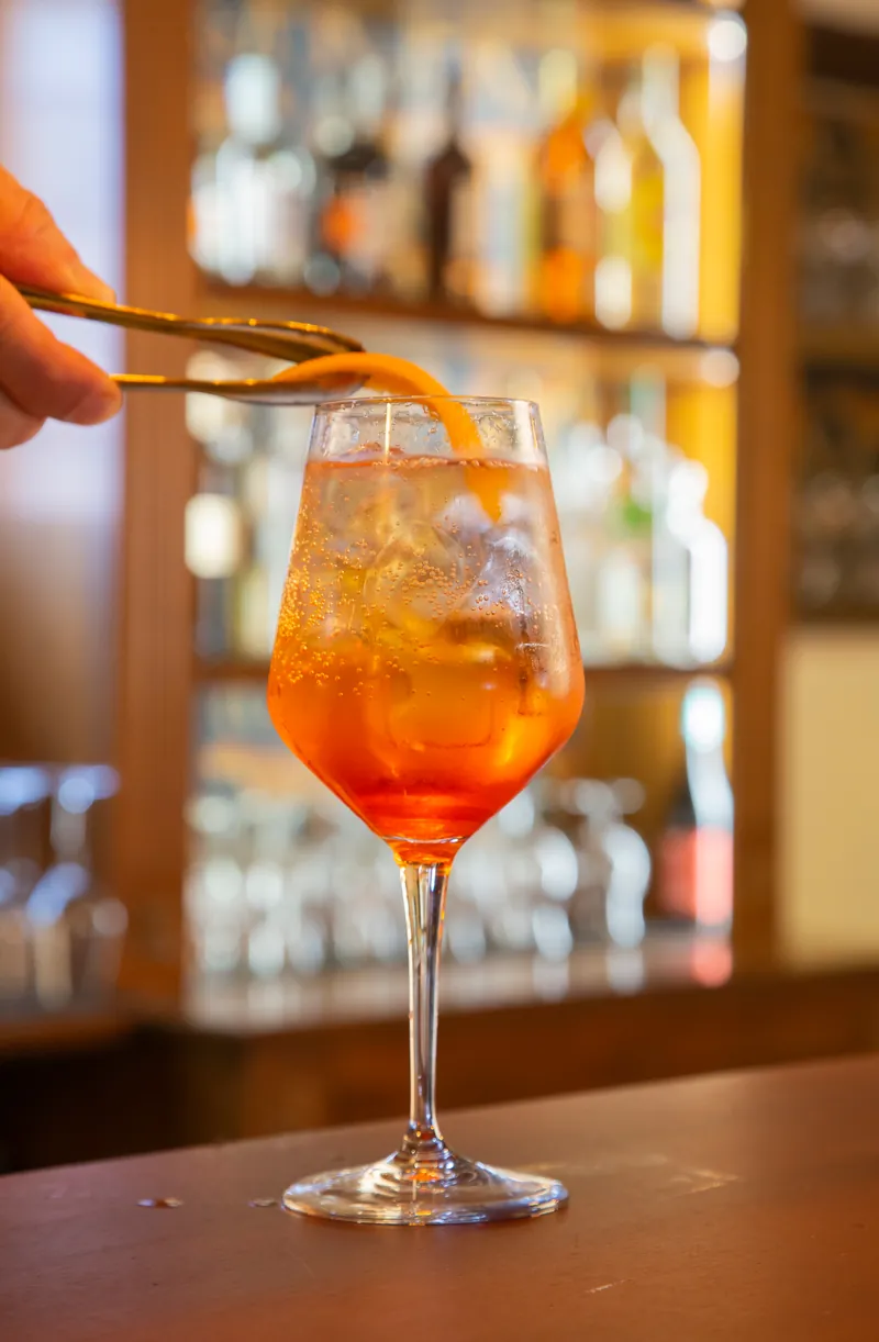 Il barman posa la scorza d'arancia sul bicchiere