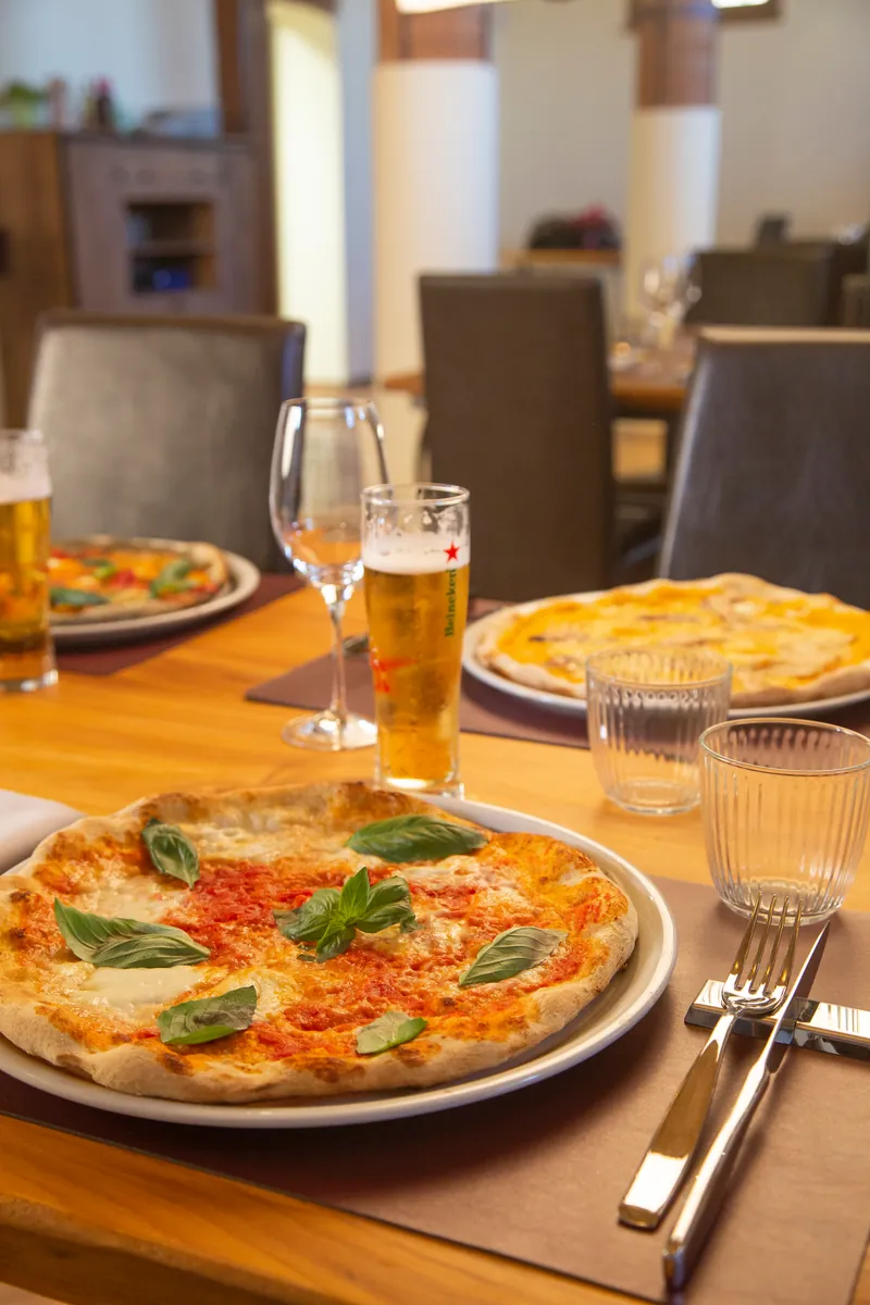 Una pizza margherita in tavola, con la birra