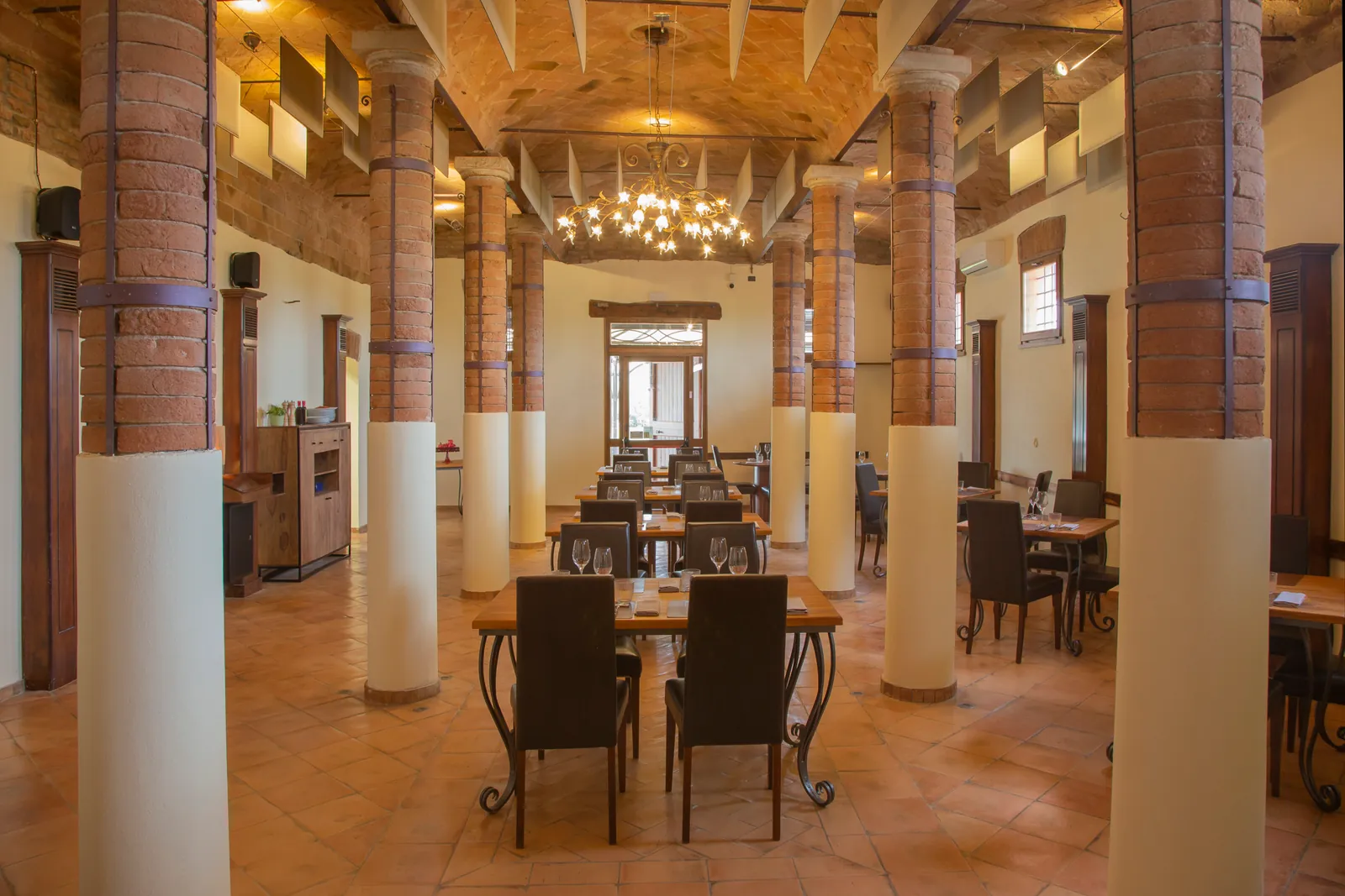La sala del ristorante con le colonne in mattone e i tavoli apparecchiati
