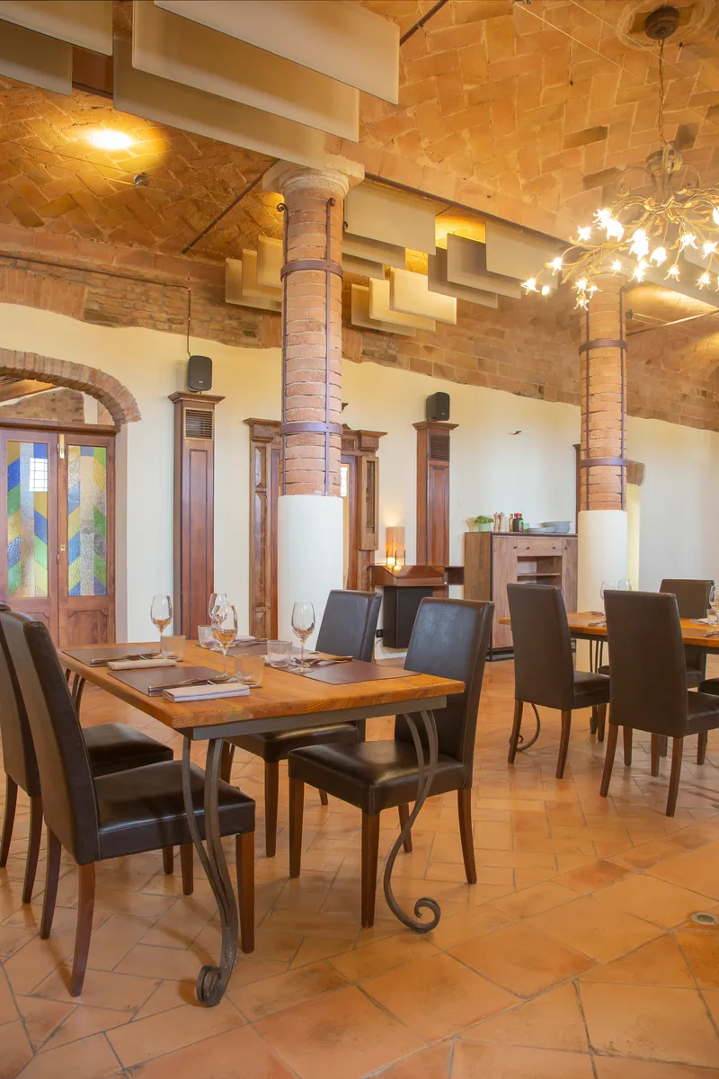 La sala delle colonne con le volte in mattoni a vista e le porte a vetri colorati