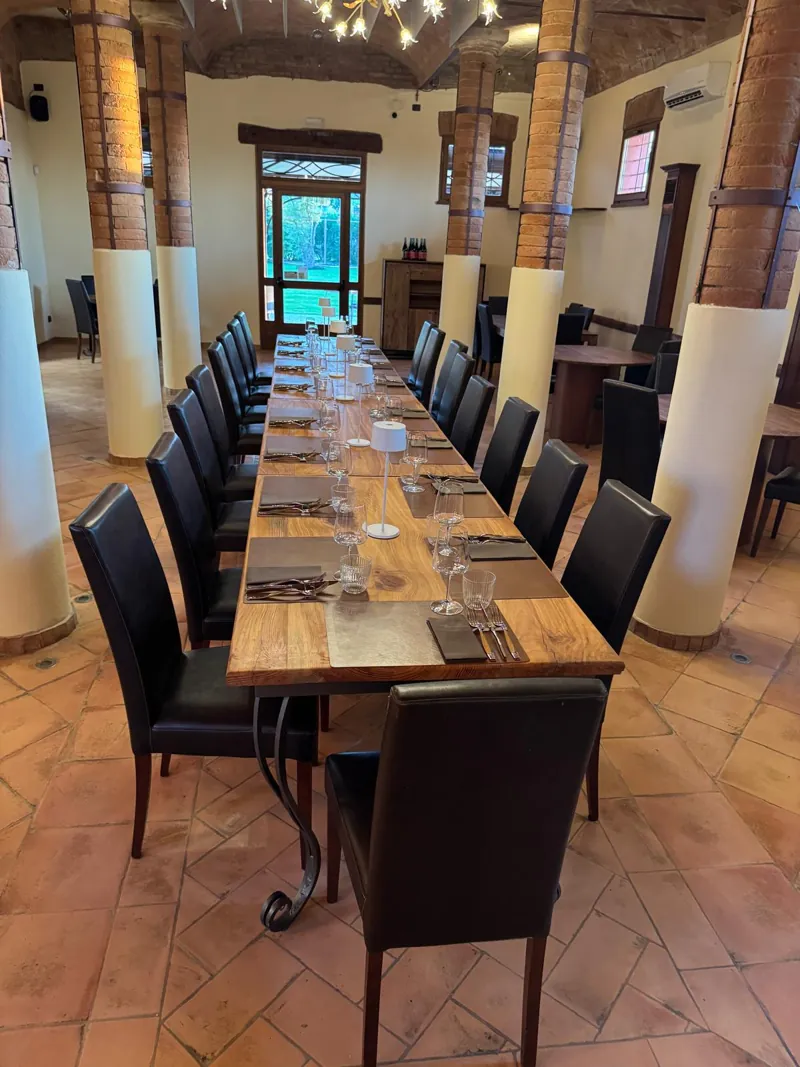 La sala del ristorante con le colonne in mattone e il tavolo imperiale