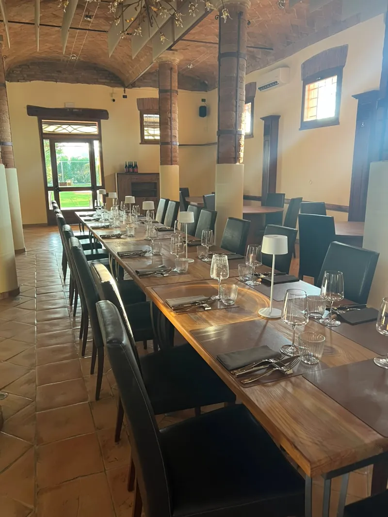 Tavolo apparecchiato sotto la parete in mattoni, pronto per la cena